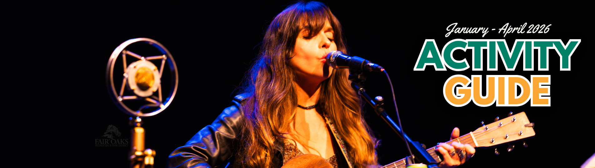 image of woman on a dark background singing and playing the guitar